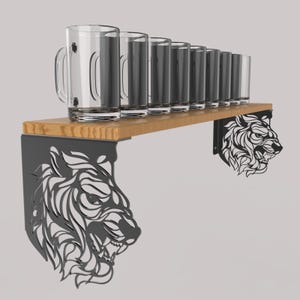 May include: A wooden shelf with black metal tiger head brackets. The shelf holds eight clear glass mugs and glasses. The brackets are cut-out designs of a tiger's head. The shelf is made of light-colored wood.