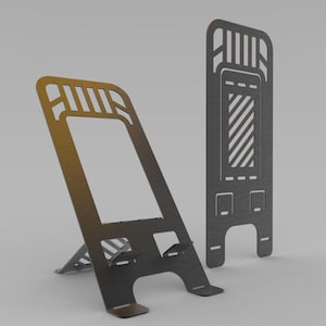 May include: Two metal phone stands. One is angled with a support leg, the other is upright. Both are dark gray with cut-out designs. The angled stand has a rectangular opening and a slot for the phone to rest on.