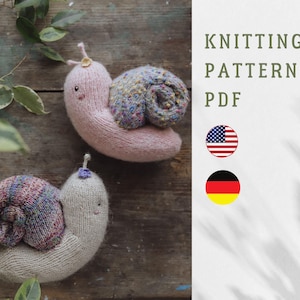 May include: Two knitted snail toys in pink and beige with colorful shell details. The image includes the text "KNITTING PATTERN PDF" and the American flag.