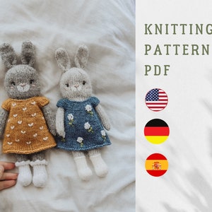 May include: Knitting pattern PDF for two gray bunny dolls wearing dresses. The bunny on the left is wearing a yellow dress with white hearts. The bunny on the right is wearing a blue dress with white flowers. The pattern is available in English, German, and Spanish.