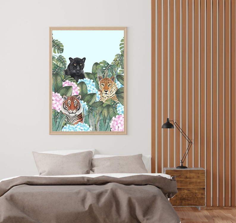 May include: A framed print featuring a black panther, a tiger, and a leopard in a jungle setting with blue and pink flowers. The animals are looking directly at the viewer.