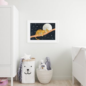 May include: A white framed print of a tiger sleeping on a branch with a full moon and stars in the background.