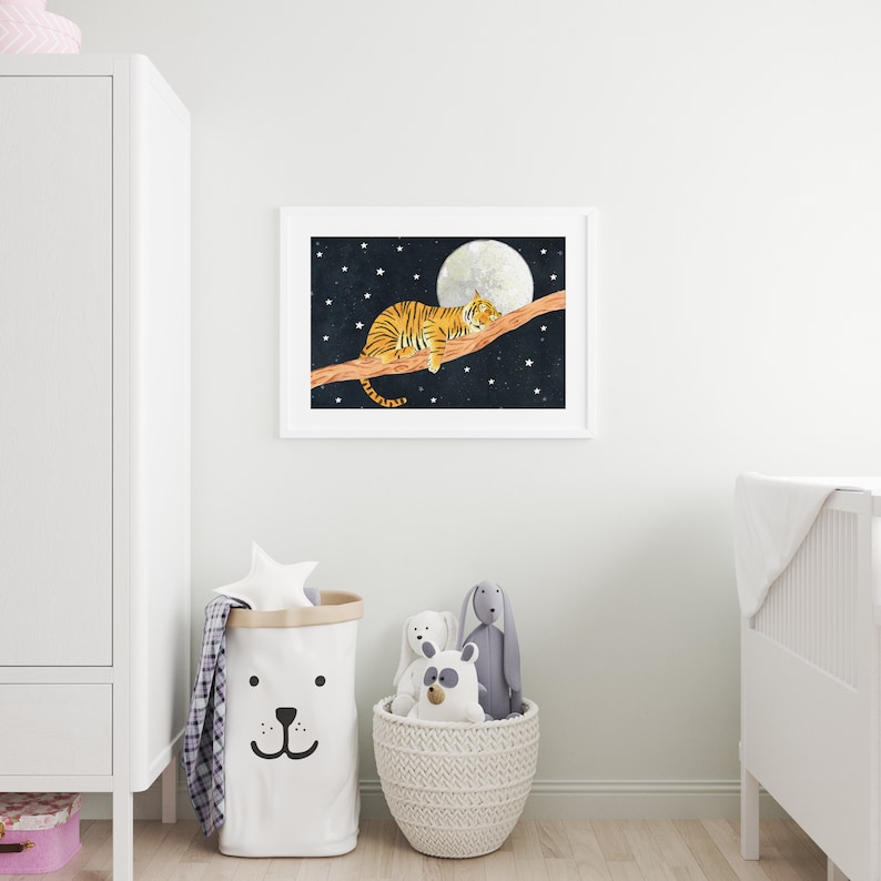 May include: A white framed print of a tiger sleeping on a branch with a full moon and stars in the background.
