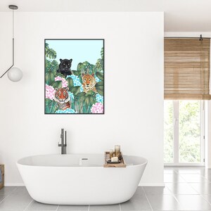 May include: A framed illustration of three wild cats, a black panther, a tiger, and a leopard, peeking out from behind lush green leaves and pink hydrangeas.