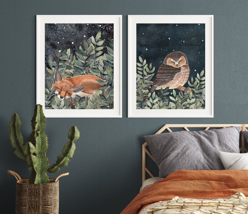 May include: Two framed illustrations, one depicting a sleeping fox in a forest setting with a starry night sky, and the other depicting a sleeping owl in a similar forest setting with a starry night sky.