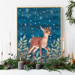 May include: A watercolor painting of a fawn standing in a snowy forest. The fawn is brown with white spots and has a white tail. The background is a dark blue with white snowflakes.