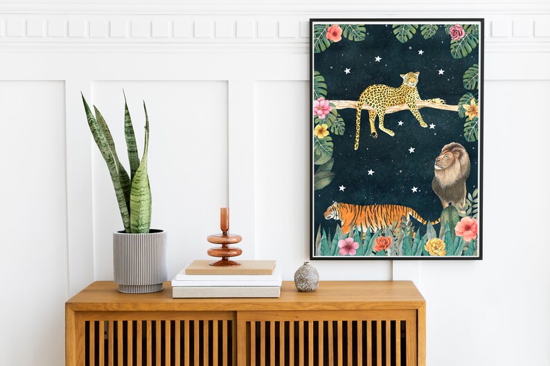 Pu&ograve; includere: Una stampa incorniciata con uno sfondo blu scuro che presenta una tigre, un leopardo e un leone in un ambiente di giungla con stelle. Gli animali sono raffigurati in uno stile fantasioso con colori vivaci.