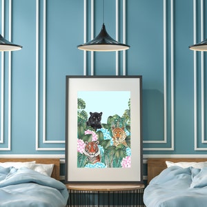 May include: A framed print featuring three tigers in a jungle setting. The tigers are a black panther, a Bengal tiger, and a jaguar. The tigers are surrounded by lush green foliage and pink flowers.