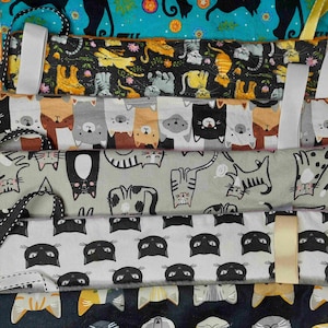 Peut inclure: Cinq bandeaux en tissu sur le thème du chat avec des motifs différents. Le bandeau du haut a un fond noir avec des chats jaunes, orange et blancs. Le deuxième bandeau a un fond gris avec des chats noirs, blancs et orange. Le troisième bandeau a un fond gris clair avec des chats noirs, blancs et orange. Le quatrième bandeau a un fond blanc avec des chats noirs. Le bandeau du bas a un fond bleu foncé avec des chats orange, blancs et gris.