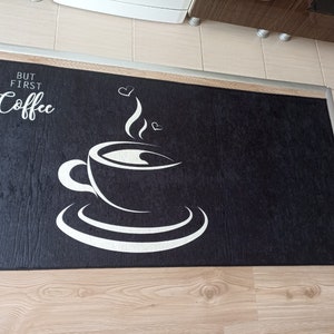 May include: Black and white kitchen mat with the text "But first, coffee" and a stylized image of a coffee cup with steam rising from it.