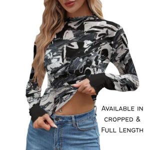 May include: A long-sleeve top featuring a black, white, and gray marbled pattern with solid black cuffs and a high neckline. The text on the right side reads: AVAILABLE IN CROPPED & FULL LENGTH. The garment is paired with blue denim jeans.