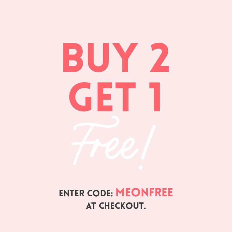 May include: A light pink background with the text "BUY 2 GET 1 Free!" in coral-colored block letters and white cursive. Below, the text "ENTER CODE: MEONFREE AT CHECKOUT" is displayed.