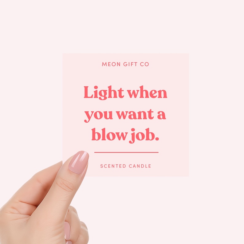May include: A pink square card held by a hand, with the text "Light when you want a blow job." in red. The text "MEON GIFT CO" is at the top, and "SCENTED CANDLE" is at the bottom.