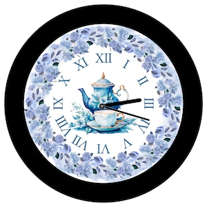 May include: Round wall clock with a black frame. The clock face features a blue teapot, teacup, and floral design. Roman numerals mark the hours, and the hands are black.