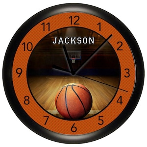 May include: Black and orange basketball themed clock with the name "JACKSON" printed on the face. The clock features a basketball on a hardwood court.
