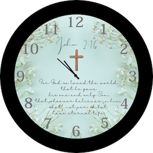 May include: A black and white clock with a light blue face. The clock has a wooden cross in the center and the text "John 3:16" above it. The text "For God so loved the world that he gave his one and only Son, that whoever believes in him shall not perish but have eternal life" is printed around the clock face.
