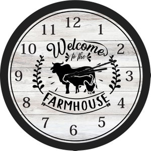 May include: A white farmhouse-style clock with black numbers and a black border. The clock face features a cow, a calf, and a chicken with the text "Welcome to the Farmhouse".