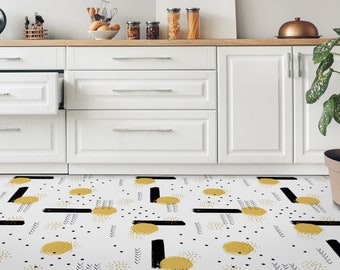 Puede incluir: Un suelo de cocina blanco con un patrón geométrico negro y amarillo. El patrón presenta pinceladas negras, círculos amarillos y pequeños puntos negros.