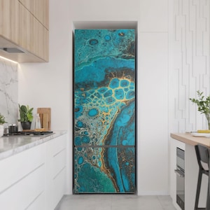 Peut inclure: Un réfrigérateur avec un design abstrait personnalisé. Le design présente un mélange de couleurs turquoise, dorées et noires, créant un effet marbré. Le réfrigérateur est dans une cuisine moderne avec des armoires blanches et un comptoir en marbre.