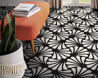 Puede incluir: Alfombra de área con estampado en blanco y negro con un otomano blanco y naranja y una planta en maceta en primer plano.