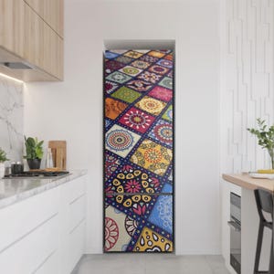 Puede incluir: Un refrigerador con una puerta estampada y colorida. El diseño presenta un mosaico de cuadrados en varios colores, incluyendo azul, rojo, amarillo y verde, con intrincados patrones estilo mandala. El refrigerador está en una cocina moderna.