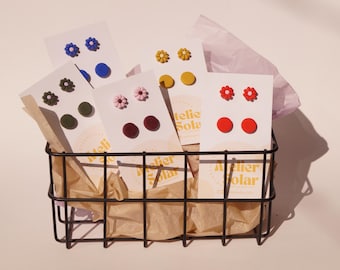 May include: A set of five pairs of handmade polymer clay earrings in a black wire basket. The earrings are displayed on white cards with the text "Atelier Solar". The earrings include red, green, blue, yellow, and pink flower designs.