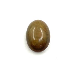 May include: A polished, oval-shaped gemstone with a warm, golden-brown hue. The stone has a smooth, reflective surface, and the color varies slightly throughout, creating a natural, earthy appearance. The gemstone is set against a white background.