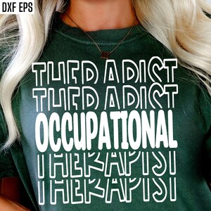 以下が含まれることがあります： 白いブロック文字で「OCCUPATIONAL THERAPIST」と書かれた濃い緑色のTシャツ。テキストは縦に積み重ねられ、一番下に「THERAPIST」という単語が2回繰り返されています。シャツはクルーネックで半袖です。