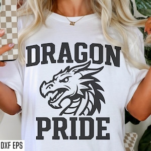 May include: White t-shirt with a black dragon graphic and the words "DRAGON PRIDE" in bold letters. The dragon is a detailed illustration. The shirt is a casual wear item.