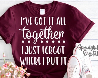 Könnte beinhalten: Burgunderfarbenes T-Shirt mit weißem Text, der lautet: "Ich habe alles zusammen... Ich habe nur vergessen, wo ich es hingelegt habe".