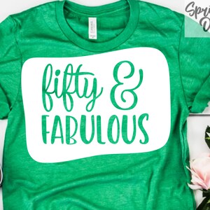 May include: Green t-shirt with a white square design that says "fifty & fabulous" in a cursive font.