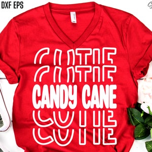 Könnte beinhalten: Rotes T-Shirt mit weißem Text, der "Candy Cane Cute" lautet, mit einem Design aus Zuckerstangen um den Text herum.