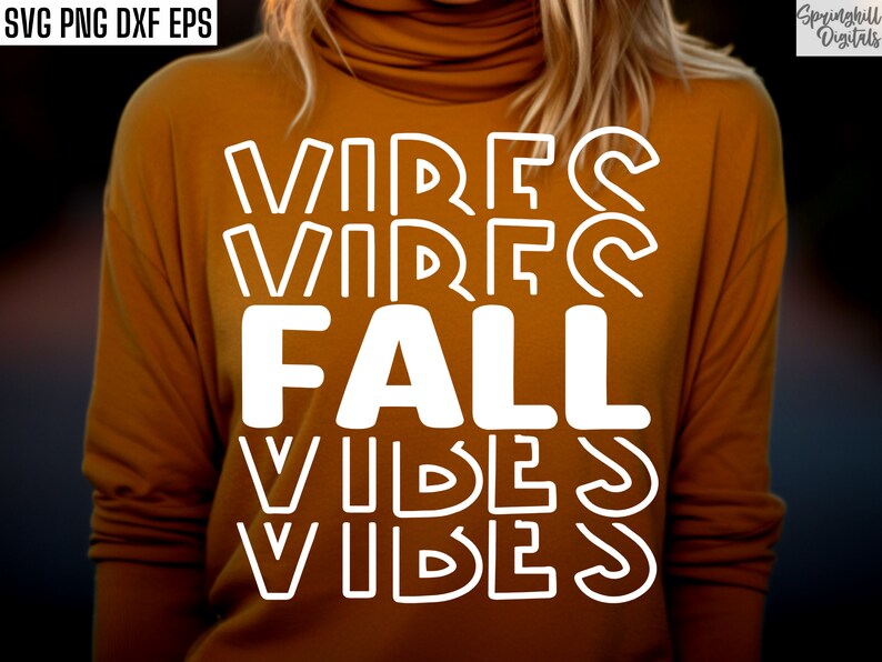 K&ouml;nnte beinhalten: Ein senfgelbes Langarmshirt mit dem Text "Fall Vibes" in wei&szlig;en umrandeten Buchstaben.
