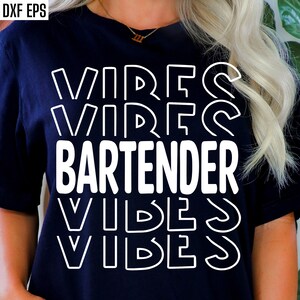 Pode incluir: Uma camiseta azul escura com texto branco que diz "VIBES BARTENDER VIBES". O texto está em negrito e com contorno.