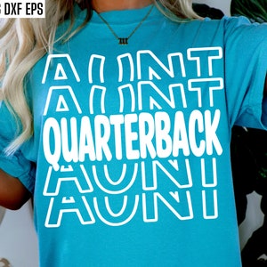 Op de afbeelding: Een turquoise blauw t-shirt met de tekst "AUNT QUARTERBACK AUNT" in witte omrande letters.