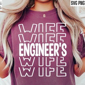 May include: A purple t-shirt with the text "Wife Engineer's Wife" in white outlined letters.
