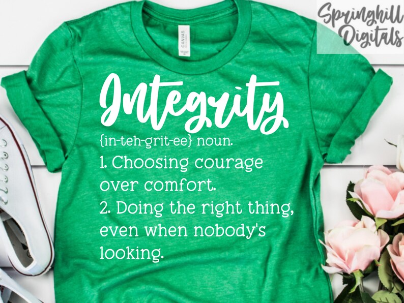 May include: Green t-shirt with white text that reads "Integrity {in-teh-grit-ee} noun. 1. Choosing courage over comfort. 2. Doing the right thing, even when nobody's looking."