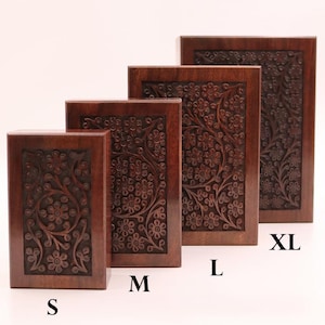 May include: Four wooden boxes of varying sizes, labeled S, M, L, and XL. Each box is a rich brown color and features a detailed floral carving on the front. The boxes are arranged in a row, showcasing the different sizes.