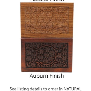 May include: Two wooden boxes with floral carvings. The top box has a natural finish, while the bottom box has an auburn finish. The boxes are rectangular and feature detailed floral patterns on their lids. The text "Natural Finish" and "Auburn Finish" are displayed.