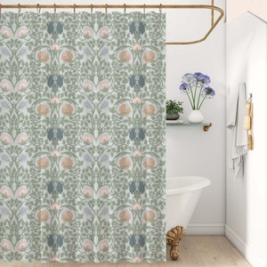 May include: A shower curtain with a floral pattern in shades of green, pink, and blue. The pattern features stylized flowers and leaves. The shower curtain is hanging in a bathroom with a white bathtub and a white tiled floor.