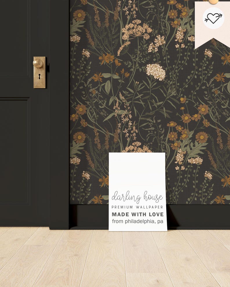 Puede incluir: Un cartel blanco con el texto "darling house PREMIUM WALLPAPER MADE WITH LOVE from philadelphia, pa" se apoya en una pared marr&oacute;n oscuro con un patr&oacute;n de papel tapiz floral.