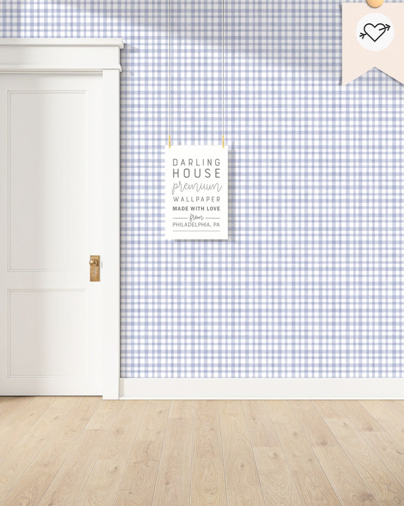 May include: A white door with a gold door handle is next to a wall covered in a light blue and white gingham wallpaper. A white sign with black text hangs on the wall. The sign reads "DARLING HOUSE premium WALLPAPER MADE WITH LOVE from PHILADELPHIA, PA."