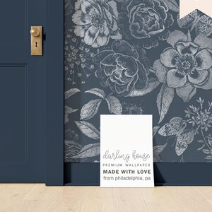 May include: A white card with the text "darling house PREMIUM WALLPAPER MADE WITH LOVE from philadelphia, pa" on a blue background with a floral pattern.