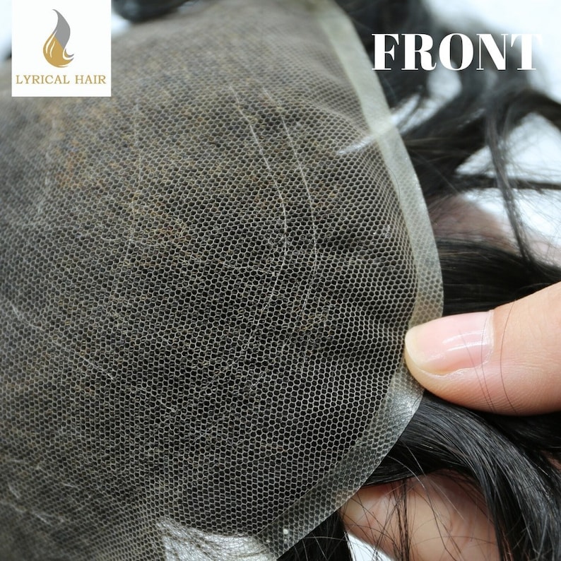 May include: A close-up of a hairpiece with a lace front. The lace is a fine mesh and the hair is black. The word "FRONT" is printed on the lace.