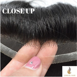 May include: Close-up of a black lace front wig with a sheer lace base. The lace is stretched and held by a hand.