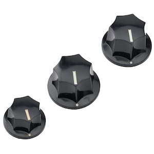 May include: Three black plastic guitar knobs with a white line on each. The knobs are different sizes.