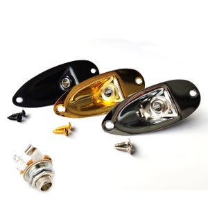 May include: Three guitar jack plates in black, gold, and chrome, with matching screws. A separate jack and additional screws are also visible. These guitar parts are for instrument repair or customization.