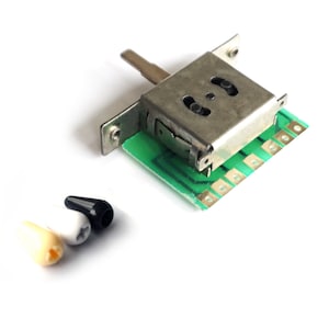 May include: Three guitar knobs in different colors: cream, white, and black. The knobs are made of plastic and have a smooth, rounded shape. The knobs are used to control the volume and tone of a guitar.