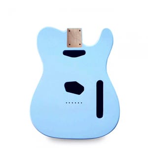 Könnte beinhalten: Ein hellblaues Gitarrenkorpus mit Aussparungen für Tonabnehmer, Bedienelemente und Hals. Der Korpus besteht aus Holz und hat eine glatte, lackierte Oberfläche. Die Halstasche ist oben sichtbar. Dies ist ein Gitarrenkorpus im Telecaster-Stil.