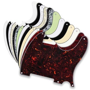 May include: A collection of guitar pickguards arranged in a fan shape. The pickguards feature various finishes including solid white, solid black, cream, mint green, and several marbled patterns in shades of red, brown, grey, and black.
